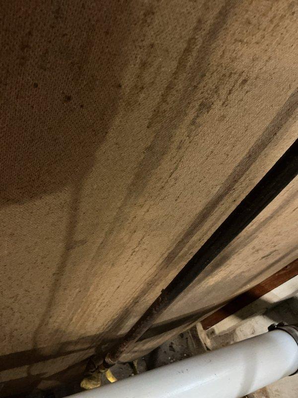 Responded to service call for reported gas leak. Upon inspection, identified leaking connection points in the basement gas line system that included galvanized and copper piping with multiple valves and joints. Observed water damage on ceiling/subflooring near plumbing fixtures, suggesting possible correlation with the gas line issue. Performed pressure test to confirm leak location, repaired compromised connections, and restored gas service after verifying system integrity.