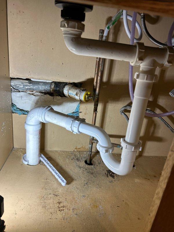 Responded to a service call for a clogged sink, where customer required Spanish communication. Upon inspection, found deteriorated P-trap assembly with compromised drainage connections. Cleared the clog using professional equipment and replaced damaged PVC drain components, ensuring proper connection to the main vertical waste stack in basement. All work was completed after customer approved the estimate on-site.