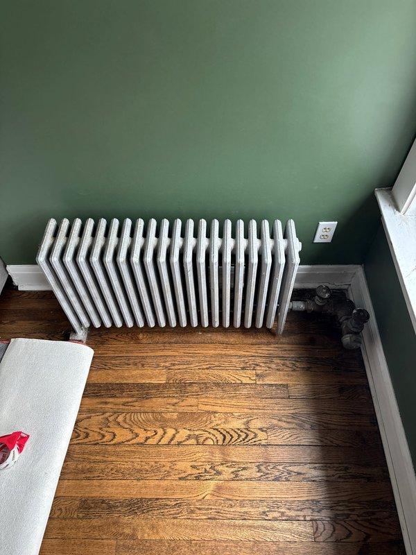 Responded to service call regarding noisy radiators in multi-unit condo. Inspected column-style radiator exhibiting hissing and clanking noises. Identified air trapped in system and performed bleeding procedure on radiator valves to release excess air, restoring proper operation and eliminating noise issues.