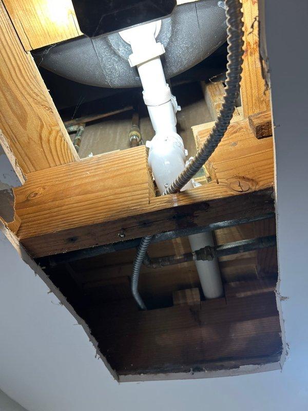 Completed sold repair job involving the inspection and servicing of exposed drain line infrastructure through ceiling access points. Cut ceiling openings to access and service the plumbing system, which included PVC drain lines with P-trap components and associated metal piping connections. Work was performed as previously discussed with homeowner, with all specified repairs completed according to the original scope of work.