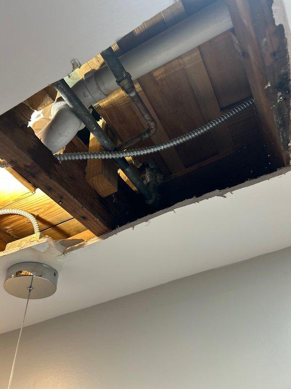 Completed sold repair job involving the inspection and servicing of exposed drain line infrastructure through ceiling access points. Cut ceiling openings to access and service the plumbing system, which included PVC drain lines with P-trap components and associated metal piping connections. Work was performed as previously discussed with homeowner, with all specified repairs completed according to the original scope of work.