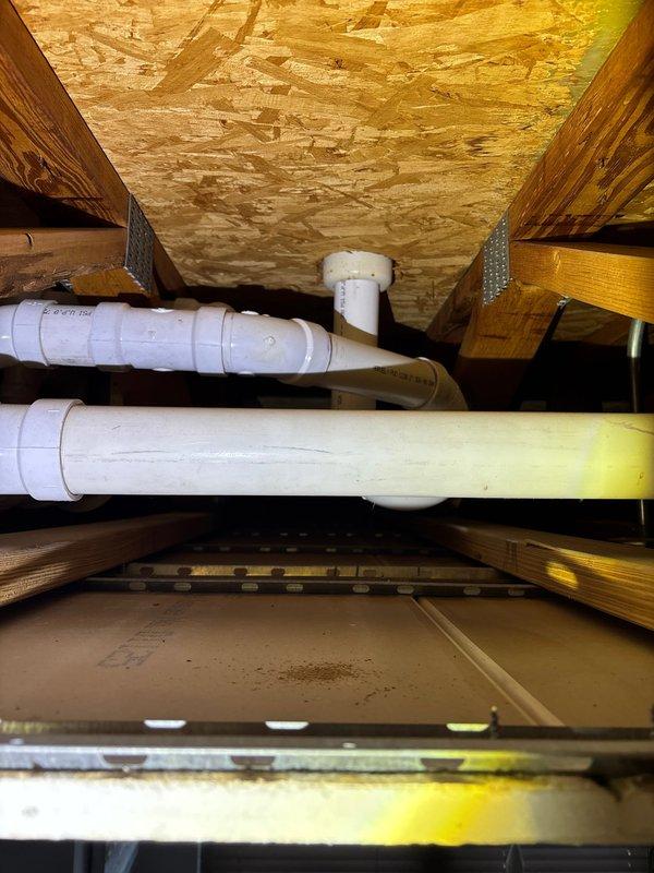Responded to water leak report where customer observed water marks on 2nd floor ceiling extending from master bathroom to living room. Conducted thorough inspection of the attic space, examining insulation for moisture damage and potential mold formation. Traced plumbing system through the structural cavity, identifying PVC supply lines and drainage pipes running along floor joists. Located and documented the source of the leak in the ceiling infrastructure.
