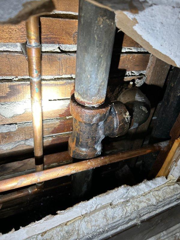 Identified and repaired significant water leak in bathroom sink plumbing that was affecting unit below. Inspection revealed heavily corroded galvanized P-trap assembly with failing connection points, particularly at the T-joint where severe rust had compromised the seal. Replaced damaged sections with new fittings, verified proper drainage, and confirmed leak resolution with access to the affected unit below.