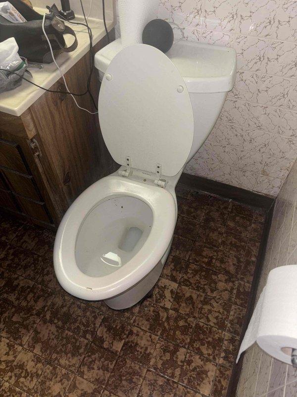 Responded to morning service call for toilet leaking at base. Upon inspection, found deteriorated toilet flange with water damage to surrounding floor tiles and mineral deposits. Removed toilet, replaced damaged wax ring and flange assembly, then reinstalled toilet with proper sealing to prevent further leakage.
