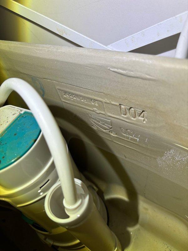 Inspected toilet tank in response to reported leak. Conducted visual examination of flush valve assembly, fill valve with blue cap, and associated plumbing components. Documented mineral deposits and water discoloration indicating potential source of leak. Took diagnostic photos of the toilet mechanism and related plumbing fixtures for assessment.