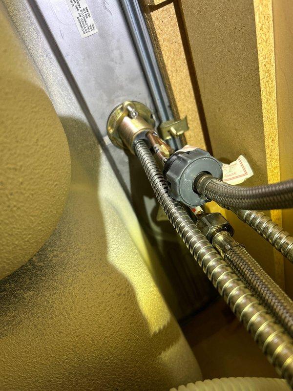 Diagnosed and repaired under-sink water leak originating from corroded chrome P-trap assembly with significant mineral buildup. Replaced damaged P-trap and inspected connected supply lines and brass fitting mounted on wall plate, ensuring proper connections and resolving the active leak that tenant had reported one day prior.