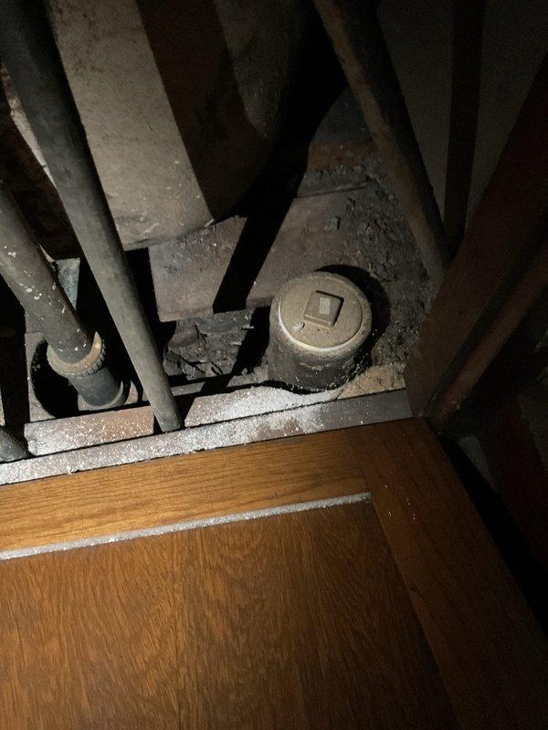 Responded to service call for bathroom drain clog. Accessed plumbing cleanout located in confined crawlspace area with significant dust accumulation. Successfully cleared obstruction in drain line, restoring proper drainage function to bathroom fixture.