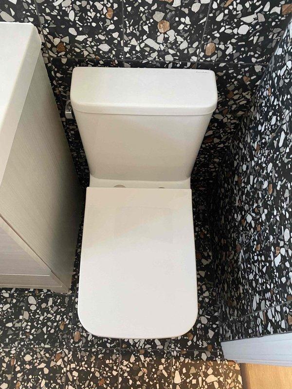 Performed assessment of existing drainage system with visible PVC piping mounted on wall, documenting multiple connection points and elbow joints requiring attention. Inspection of bathroom fixture (toilet) also conducted to evaluate integration with proposed piping modifications. Work scheduled for Monday pending consultation regarding specific fitting requirements.