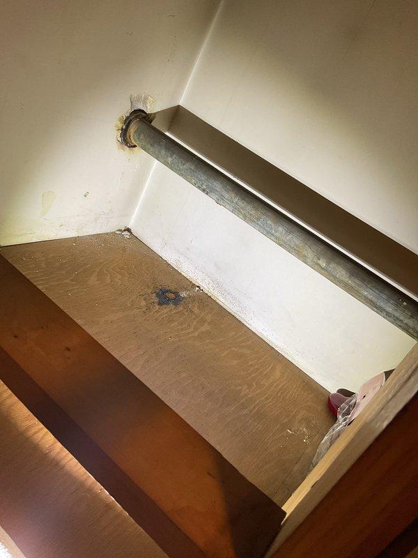 Responded to service call for suspected burst pipe under sink and main line rodding request. Inspected galvanized metal pipe showing signs of age and water damage to surrounding wooden surface. Serviced PVC plumbing installation with visible T-joint/cleanout fitting that showed discoloration and minor corrosion at connection points; cleaned and restored proper functionality to prevent further leakage.