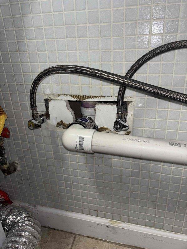 Inspected tanked water heater system and identified faulty check valve in left tankless unit. Documented existing plumbing connections and infrastructure, including PVC piping and flexible braided hoses. Will return to complete repair once warranty replacement check valve is received.