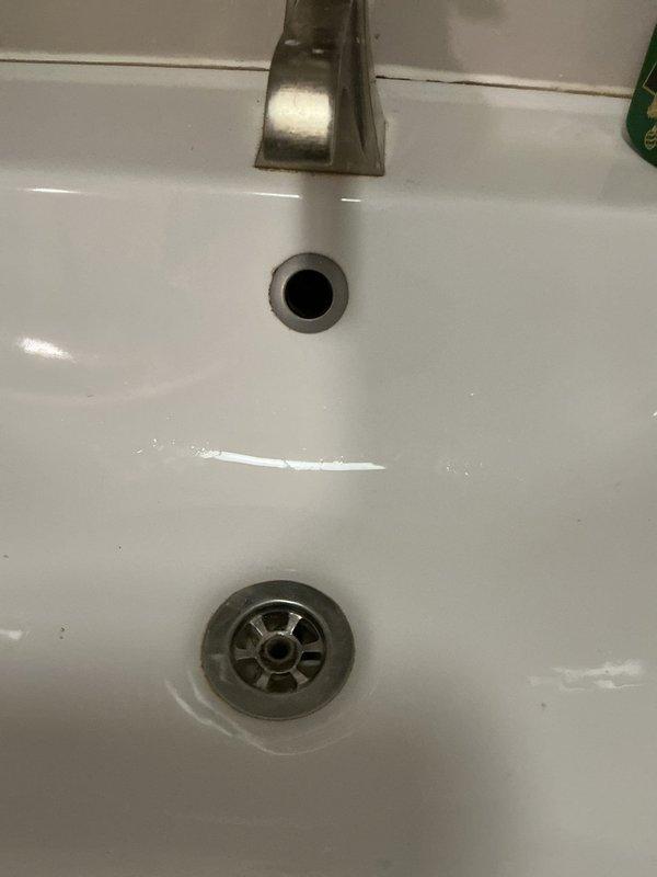 Responded to morning service call for bathroom sink leak. Upon inspection, identified a deteriorated corrugated flexible drain pipe showing significant yellowing and wear. Replaced the aging drain assembly with new PVC components and confirmed proper drainage with no further leakage.