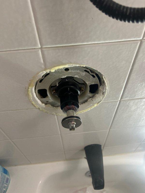 Accessed bathroom plumbing through wall access panel to perform scheduled angle stop replacement. Inspected ceiling-mounted shower valve assembly which showed signs of uneven installation with sealant deterioration around the mounting plate. Completed both the angle stop replacement and shower valve maintenance during scheduled building shutdown.