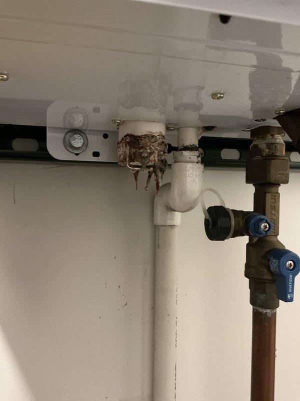 Responded to service call for tankless water heater displaying error code E110 with no hot water output. Inspection revealed significant corrosion and mineral buildup at drain pipe connection causing system failure. Replaced damaged valve assembly and pipe fitting, cleaned mineral deposits from affected components, and restored proper water flow. System tested successfully with error code cleared.