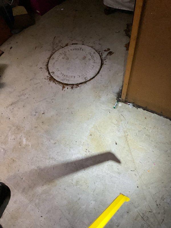 Responded to morning service call regarding clogged catch basin requiring cleaning. Upon inspection, accessed the circular metal drain cover in concrete floor area of basement utility room. Cleaned debris accumulation around perimeter of catch basin to restore proper drainage function.