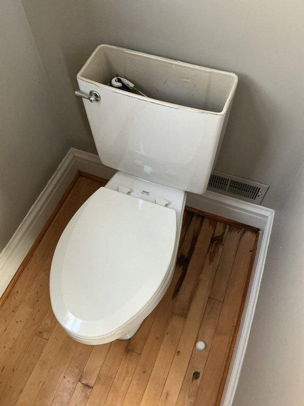 Performed inspection of toilet installation and discovered significant water damage and black mold growth around the toilet flange. Removed toilet to access damaged area, revealing deteriorated wooden flooring and compromised wax ring. Replaced wax ring and reinstalled toilet after documenting extent of water damage for customer's reference.
