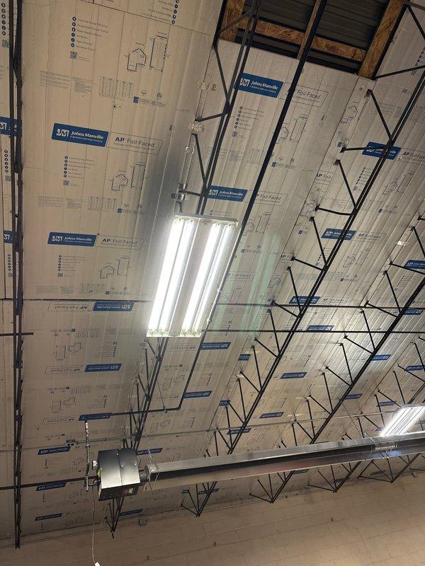 Completed installation of AP Foil-Faced insulation panels in commercial space ceiling with proper support from metal framework system. Installed and connected black piping across ceiling area, ensuring integration with existing mechanical systems. Verified operation of newly installed fluorescent lighting fixtures mounted to ceiling framework.