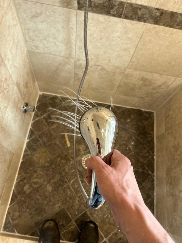 Responded to a service call regarding ceiling water leaks occurring when upstairs neighbor uses their bathtub. Conducted a thorough inspection by accessing the bathtub panel to examine plumbing connections and potential leak sources. Inspected the shower assembly including the multi-jet showerhead and flexible hose connection, identifying this as the source of water infiltration to the unit below.