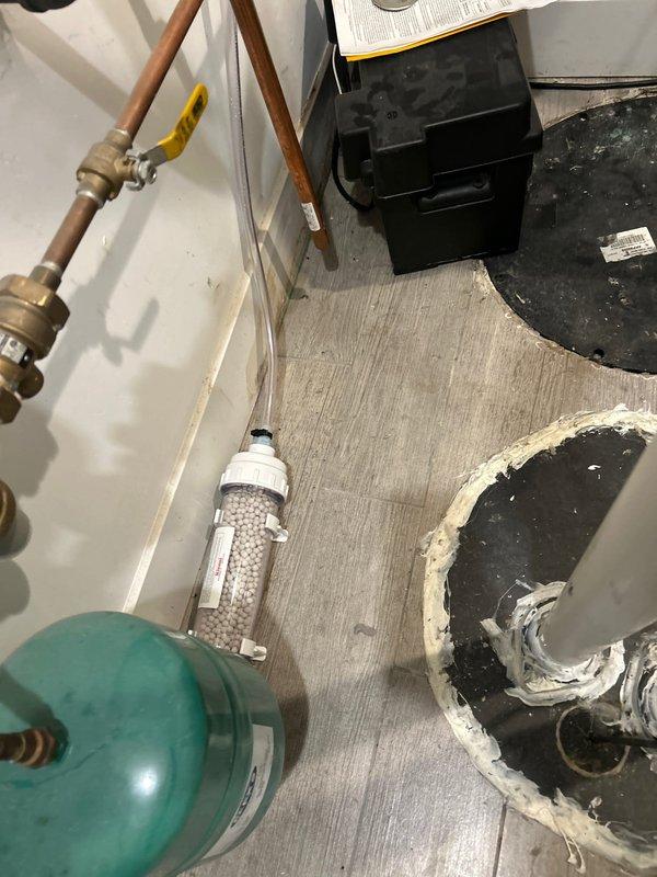 Performed inspection of existing condensate neutralizer system in mechanical room. Documented current setup including a clear cylindrical neutralizer containing white media, copper piping network with two circulation pumps, and associated valves and fittings. Prepared estimate for replacement of condensate neutralizer units to ensure proper pH treatment of acidic condensate before discharge.