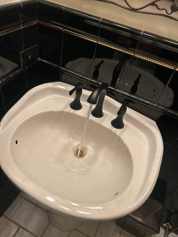 Replaced lavatory faucet in bathroom with black fixtures as per customer request. Connected new faucet to existing braided supply lines and verified proper water flow and drainage through brass P-trap. Tested for leaks and confirmed full functionality without requiring any additional repiping work.