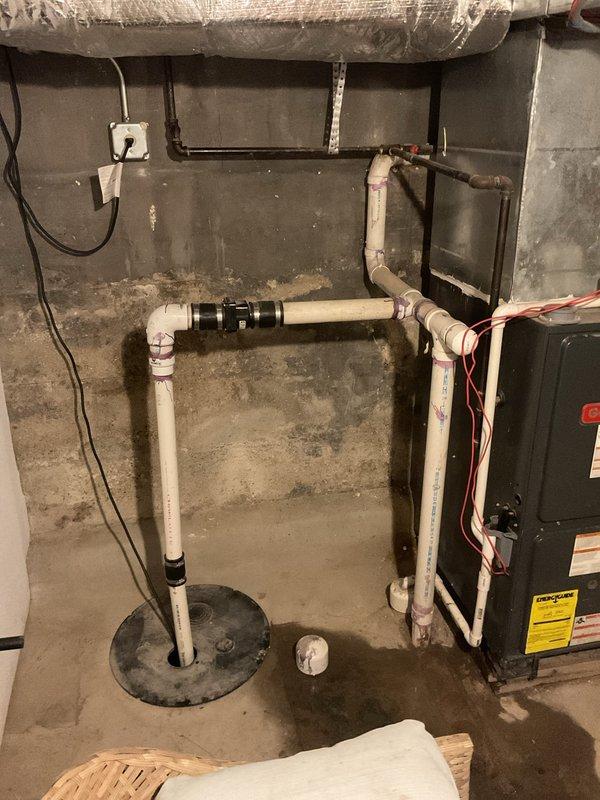 Responded to tenant complaint of sewage odors and water backup in basement laundry area. Inspection revealed damaged sump pump covers with visible cracks requiring removal. Replaced defective sump pump and reconnected to existing PVC drainage system, resolving the backup issue and eliminating sewage odors.