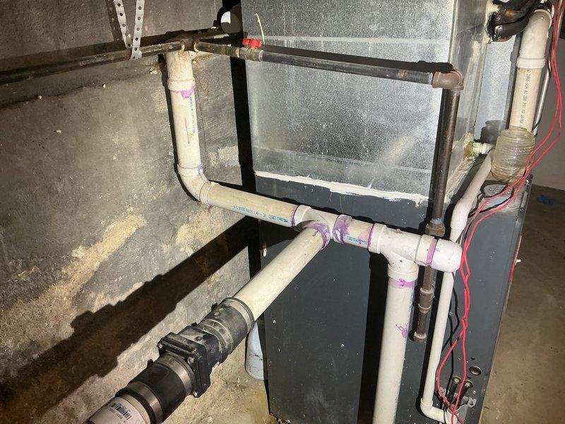 Completed assessment of existing sump pump discharge system and developed estimate for re-routing requirements. Inspection revealed current PVC discharge line with multiple 90-degree turns requiring modification. Plan includes proper re-routing of discharge piping with appropriate primer and adhesive at joints to ensure code compliance and optimal drainage performance.
