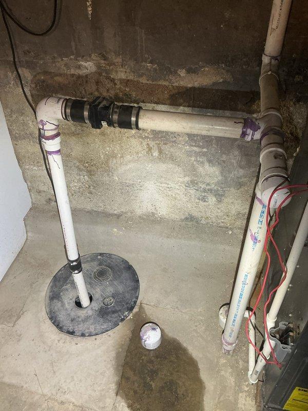 Completed assessment of existing sump pump discharge system and developed estimate for re-routing requirements. Inspection revealed current PVC discharge line with multiple 90-degree turns requiring modification. Plan includes proper re-routing of discharge piping with appropriate primer and adhesive at joints to ensure code compliance and optimal drainage performance.
