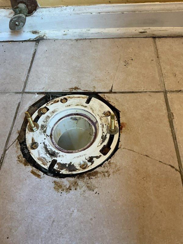 Removed deteriorated toilet flange and cleaned mounting surface. Installed new wax ring seal on replacement flange. Properly positioned and secured flange to tiled floor for optimal toilet installation.