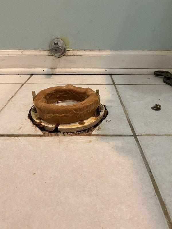 Removed deteriorated toilet flange and cleaned mounting surface. Installed new wax ring seal on replacement flange. Properly positioned and secured flange to tiled floor for optimal toilet installation.