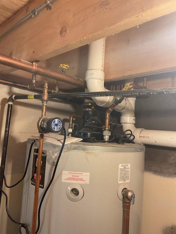 Responded to service call regarding sewer odor emanating from bathroom shower drain. Upon inspection, examined the home's plumbing system including the basement drainage setup with PVC pipes, check valve, and battery backup sump system. Also inspected water heater installation with associated copper piping and P-trap configuration to identify potential causes of the reported sewer smell.