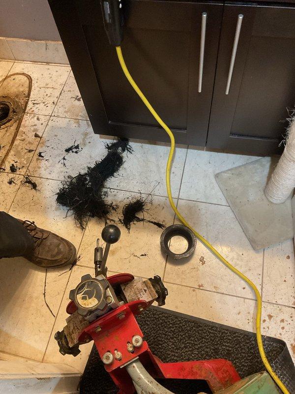 Responded to service call for slow-draining toilet with occasional bubbles and sewer odor in lower level bathroom. Performed diagnostic inspection, removed toilet to check flange height and replaced wax seal. Successfully cleared blockage in branch line using drain auger, removing significant hair and debris accumulation. Reinstalled toilet with proper seal and verified proper drainage function.