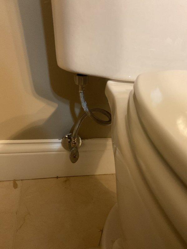 Responded to a service call for a leaking toilet supply line connection. Inspected the braided stainless steel line connected to the chrome shutoff valve and identified the source of the leak. Replaced the faulty supply line and tested the connection for proper function and absence of leaks.