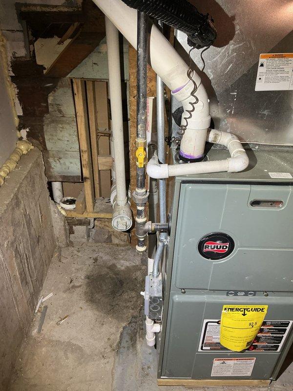 Conducted inspection of basement utility area containing Ruud HVAC system and associated plumbing infrastructure, documenting PVC drainage system with purple markings for non-potable water and various pipe connections. Provided estimate for bathroom work where existing fixtures include a white toilet, glass vanity, and shower with chrome fixtures set against ceramic tile flooring and walls.