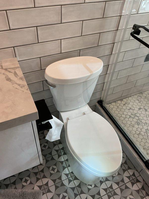 Scheduled installation of toilet in customer's bathroom with modern subway tile and glass shower enclosure. Confirmed 50% deposit received for work to be performed next week. Job requires two-person team for proper installation.