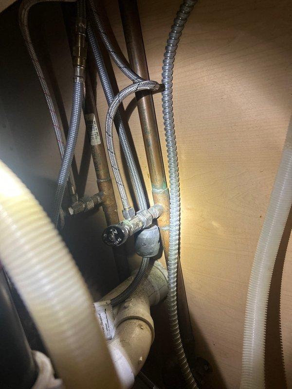 Completed shower valve replacement and installed new shut-off valves under sink. Inspected existing plumbing system including copper supply lines, PVC drainage components, and braided stainless steel water lines. Replaced worn cartridge to restore proper function and prevent future leaks.