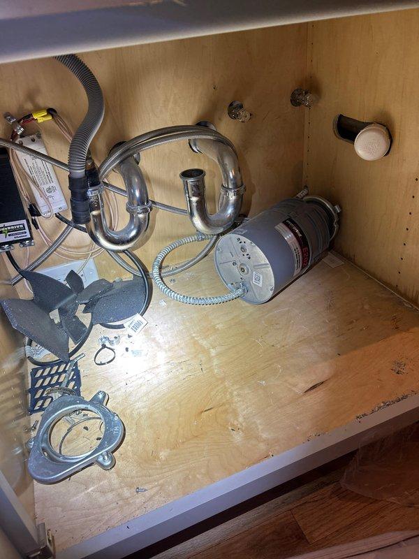 Installed two bathroom sink faucets and one shower faucet in partially constructed bathroom with exposed plumbing infrastructure. Installed new wax ring and reconnected kitchen faucet and garbage disposal unit, verifying proper drainage through P-trap assembly and ensuring no leaks in the system.