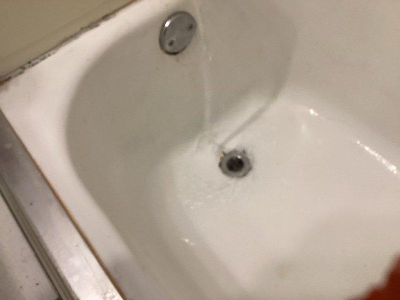 Inspected slow-draining bathtub issue reported by customer under previous P-trap replacement warranty. Examination revealed debris accumulation in drain line rather than P-trap malfunction. Cleared blockage and verified proper drainage functionality with water flow test.