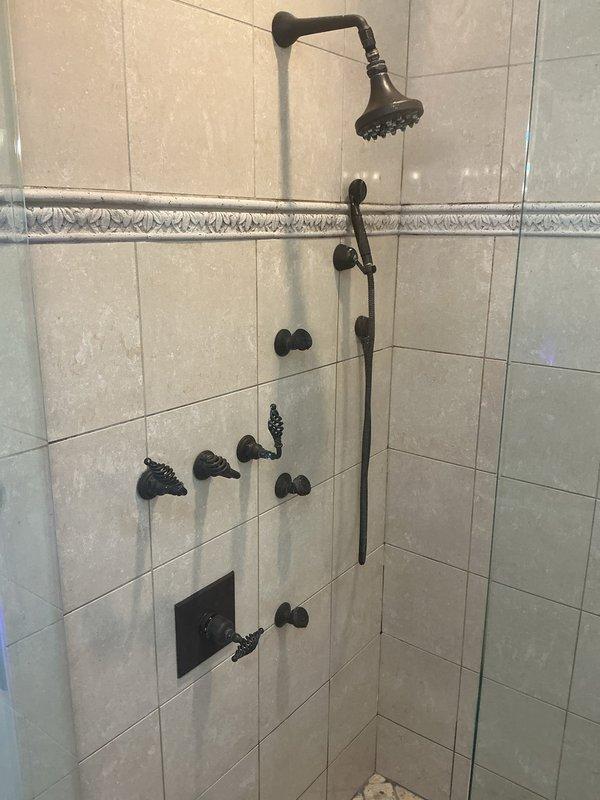 Conducted comprehensive inspection for potential sump pump installation in basement utility area, assessing existing water meter assembly and associated copper/PVC piping configuration. Also evaluated bathroom shower system with oil-rubbed bronze fixtures and provided estimate options for addressing all plumbing concerns per client request.