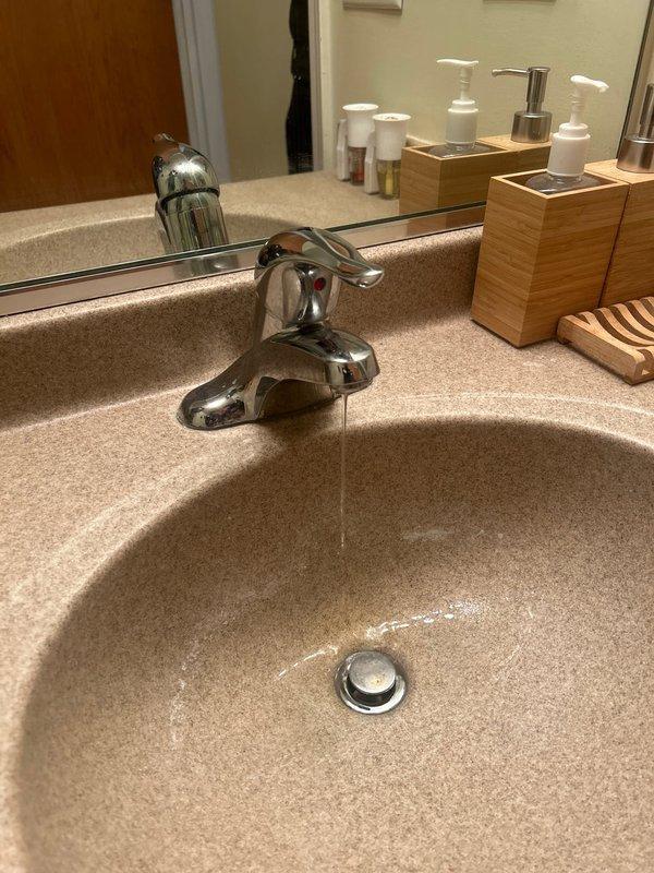 Responded to afternoon service call regarding bathroom faucet that would not shut off completely, an issue reported to be ongoing for approximately 2 months. Upon inspection, found water continuously running from chrome single-handle shower/bath fixture mounted on tiled wall and bathroom sink faucet. Repaired faulty valve components, adjusted water pressure, and verified complete water shutoff at both fixtures.