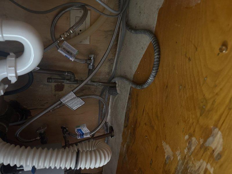 Completed installation of new double basin kitchen sink and faucet assembly as per sold repair agreement. Replaced corroded water supply lines and drain plumbing, addressing visible water damage to cabinet substrate. Job commenced after receiving required deposit as specified in service contract.