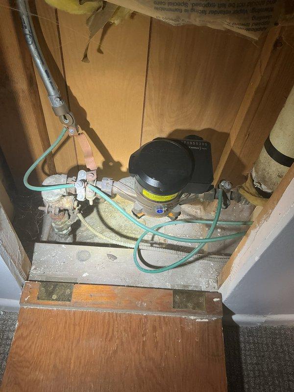 Inspected water line from home to street as requested by customer. Observed significant corrosion and mineral deposits on main valve assembly at connection point, with deteriorated metal components throughout. Evaluated existing PEX piping system and pressure regulating components for potential replacement, documenting current condition to prepare comprehensive estimate for complete water service line replacement.