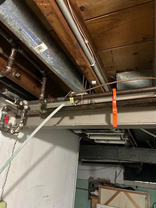 Located and repaired a water leak originating from the shower/tub enclosure that was manifesting in the basement ceiling below. Inspection revealed mineral buildup around the tub drain with water damage evident on the basement ceiling joists directly underneath the bathroom plumbing. Replaced damaged drain assembly and sealed all connections to prevent future leakage.