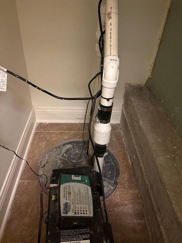 Conducted detailed inspection of commercial drainage system, documenting significant deterioration and rust on floor drain flange with visible water damage to surrounding tile. Evaluated sump pump installation, noting proper PVC discharge pipe configuration and electrical connections, recommending replacement of corroded floor drain assembly to prevent potential water intrusion issues.