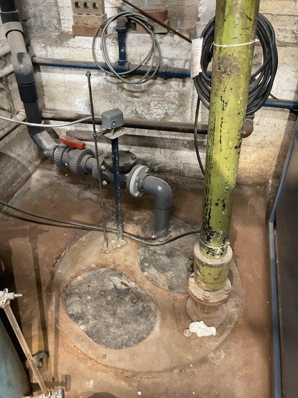 Performed comprehensive camera inspection of main sewer line and associated plumbing infrastructure as requested. Examined basement utility area with aging yellow vertical pipe and PVC connections, and inspected bathroom facilities including toilet installation with visible signs of water staining around base. Camera inspection completed with documentation of current system condition.