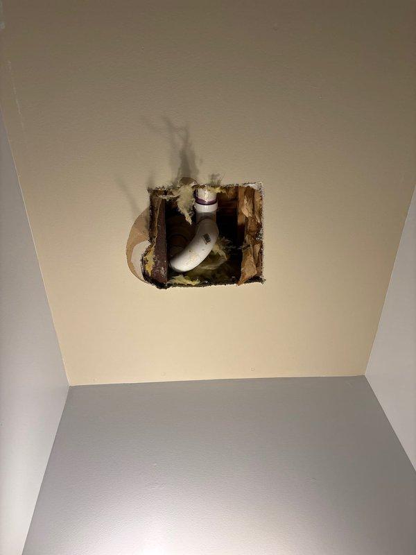 Responded to service call regarding water leak from second floor bathroom into first floor bathroom. Upon inspection, located the source of the leak at a PVC pipe connection with purple primer markings in the ceiling cavity. Created access point through ceiling drywall to facilitate repair and prevent further water damage to the surrounding structure.
