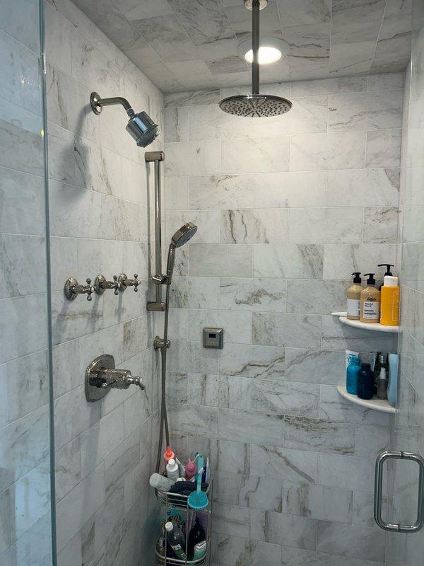 Responded to low water pressure complaint affecting shower fixtures. Upon inspection, discovered corroded and partially blocked supply pipes within wall cavity. Opened access point to replace deteriorated copper pipe sections and installed new shut-off valves to improve water flow. Tested both rainfall and wall-mounted shower fixtures after repair, confirming restoration of proper water pressure throughout the bathroom.