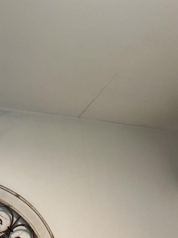 Located and diagnosed a ceiling leak originating from corroded metal drain pipes under a sink/basin in the room above. Discovered significant oxidation at pipe joints with visible moisture damage and rust stains throughout the cabinet area. Installed requested shut-off valve to address the slow drip that was penetrating the ceiling and causing water damage to the wall below.