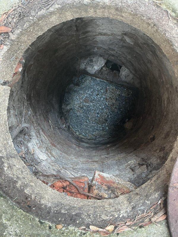 Conducted an assessment for check valve installation on residential sewer line. Inspected the utility room housing the water heater and examined the concrete drainage structure which showed signs of weathering and sediment accumulation. Determined appropriate location and specifications for backwater valve installation to prevent sewer backflow.