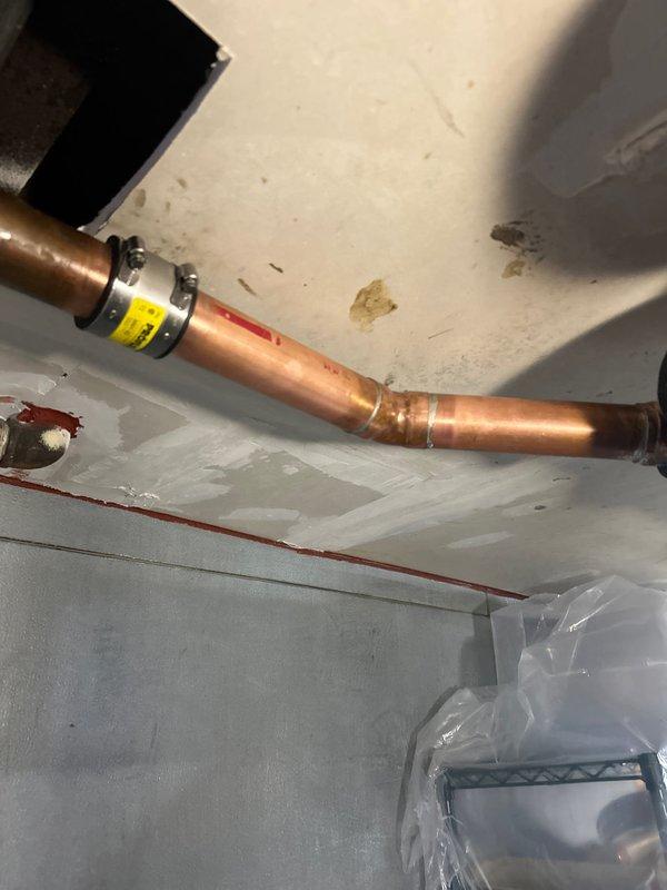 Completed copper drain line installation with proper horizontal runs and fittings. Site was prepared with protective sheeting to contain debris during work. Scheduled additional copper drain work for the following morning, with partial credit from previous rodding service applied toward scope work.