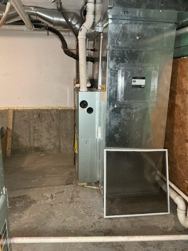 Conducted site assessment of existing Ruud furnace installation to prepare for upcoming removal and reinstallation. Documented current configuration including gas line connections, PVC ventilation pipes, condensate drainage, and electrical wiring. Photos taken of complete HVAC system showing ductwork integration and mechanical room layout for Home Comfort's estimation purposes.