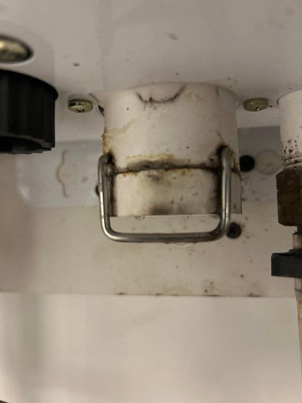 Responded to service call for a tankless water heater showing signs of water damage. Inspection revealed significant moisture damage and staining around mounting bracket with possible mold/rust development. Installed Navien kit and performed complete system flush using tankless flushing kit to restore proper functionality.
